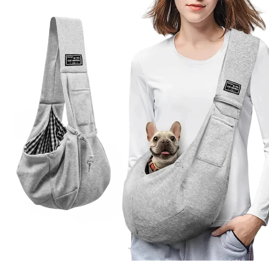 Small dog resting comfortably in gray cotton crossbody sling carrier worn by owner – vegan, breathable, hands-free design.