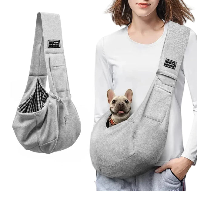 Small dog resting comfortably in gray cotton crossbody sling carrier worn by owner – vegan, breathable, hands-free design.