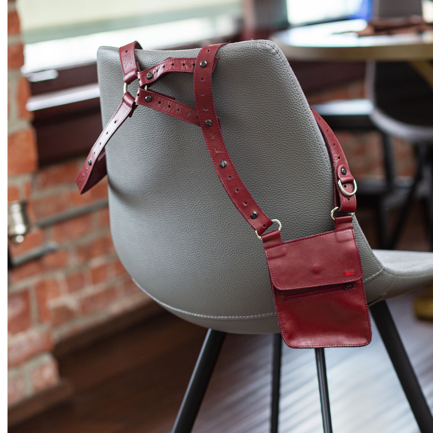 Side view of NiK Kacy Utility Holster Harness in Crimson, highlighting the structured leather design, secure wallet compartment, and modular strap adjustments.