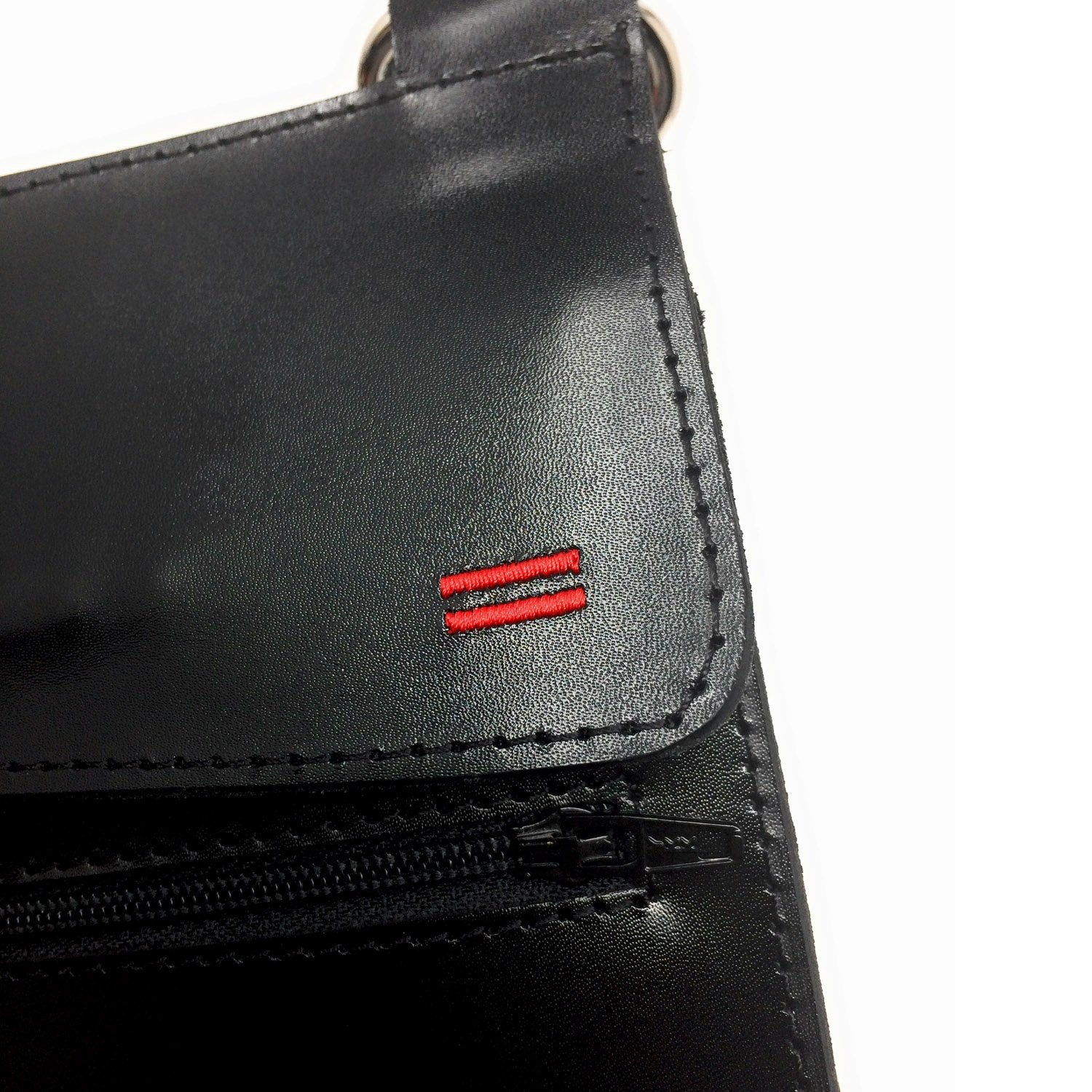 Close-up of the bag compartment on NiK Kacy Holster Harness 2.0, showcasing the red stitched equality symbol, secure YKK zipper closures and premium leather craftsmanship.