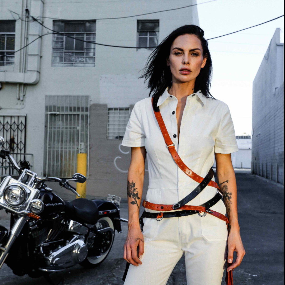 NiK Kacy's genderfree holster bags are modular in design so you can mix and match to create your own custom holster harness design. Seen here, model Teela LaRoux is wearing two holsters (1 black and 1 orange) combined together to create this apocalyptic look. 